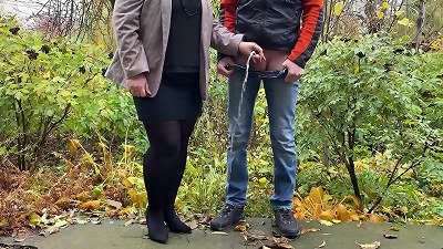 steamy mummy in pantyhose and micro-skirt holding guy's fuck-stick outdoors while peeing